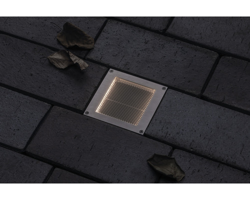 Spot encastrable au sol en métal sur pavés