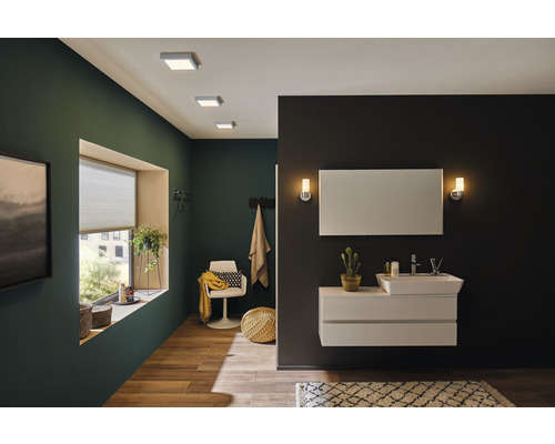 Modernes Badezimmer mit Waschbecken, Spiegel, Deckenleuchten und grünen Wänden