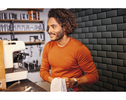 Homme dans la cuisine avec évier, machine à café et égouttoir à vaisselle