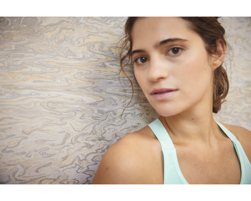 Frau vor einer Tapete mit Marmorstruktur