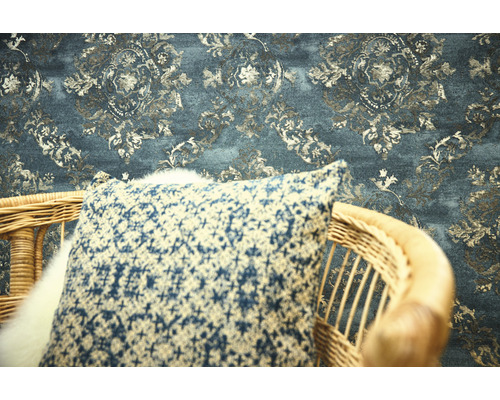 Dekoratives Interieur mit gemusterter Tapete und Kissen auf einem Stuhl