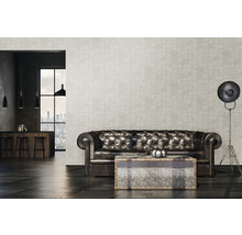 Salon avec canapé en cuir et papier peint à motifs