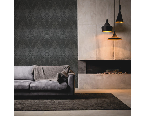 Wohnzimmer mit gemusterter Tapete, Sofa, Teppich und Pendelleuchten