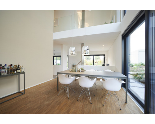 Salle à manger lumineuse avec table, chaises et suspensions dans une maison moderne