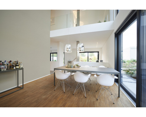 Salon lumineux avec table à manger, chaises, éclairage et grande fenêtre.