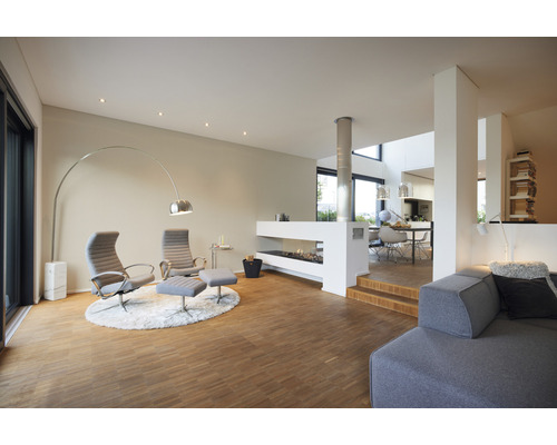 Helles Wohnzimmer mit Sesseln, Kamin und Holzboden.