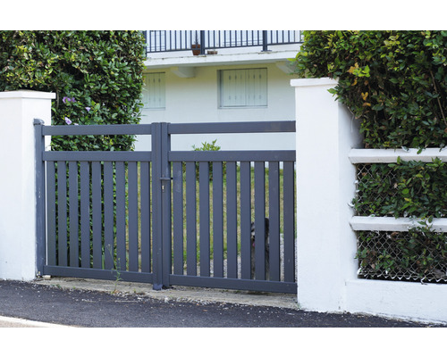 Portail de jardin en métal gris entre deux piliers blancs