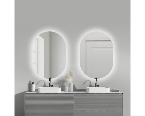 Badezimmer mit Doppelwaschtisch, zwei beleuchteten Spiegeln und grauen Unterschränken.