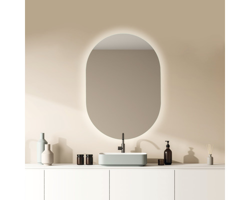 Badezimmer mit ovalem Spiegel, Aufsatzwaschbecken und Armaturen auf einem weißen Waschtisch