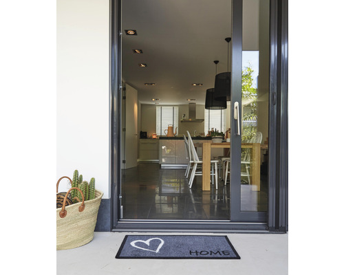 Eingangsbereich mit Fussmatte, Korb und Blick in die Küche