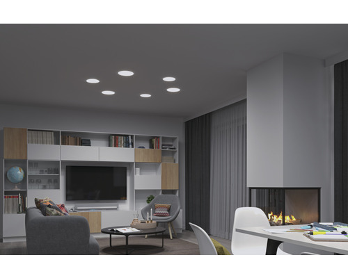 Wohnzimmer mit Einbaustrahler an der Decke, Bücherregal, Fernseher und Kamin.