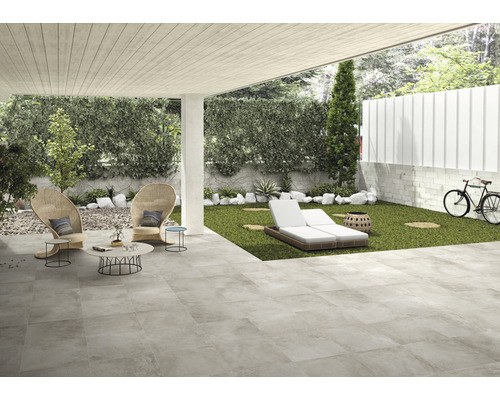 Terrasse avec sol en pierre, chaises longues et aménagement paysager pour l''extérieur.