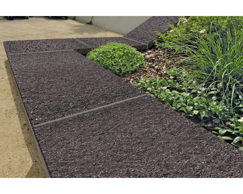 Aménagement de jardin avec bordures de parterre en matériau sombre et plantes