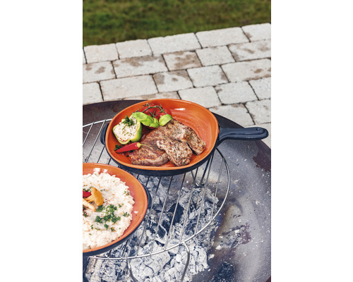 Zwei Pfannen mit Fleisch und Reis auf einem Grill über Holzkohle.