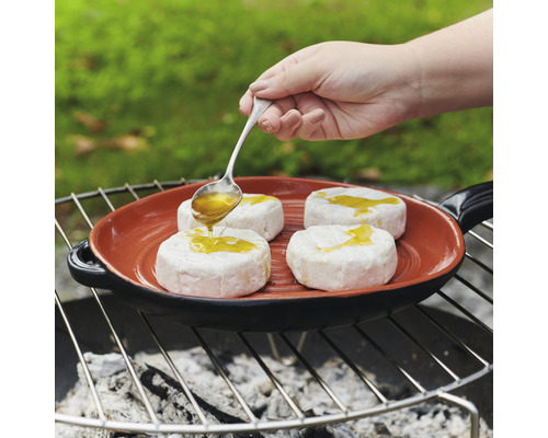 Gebratener Käse wird mit Honig auf einer Grillpfanne beträufelt