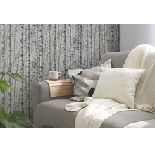 Wohnzimmer mit grauer Couch, Kissen, Decke und Tapete mit Birkenmotiv