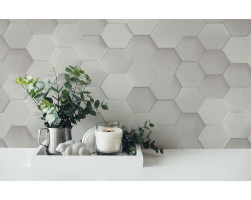 Mur décoratif avec carreaux hexagonaux, arrangement avec bougie, plante et décoration sur un plateau