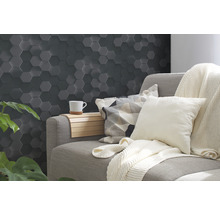 Wohnzimmer mit grauer Wandverkleidung in Hexagonform, Sofa und Dekoration