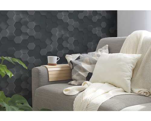Wohnzimmer mit grauer Wandverkleidung in Hexagonform, Sofa und Dekoration