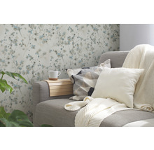 Wohnzimmer mit gemusterter Tapete, Sofa, Kissen und Getränkehalter