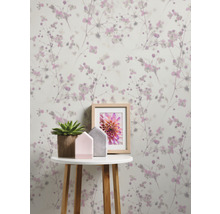 Zimmeransicht mit Blumentapete, Tisch, Topfpflanze und Bilderrahmen