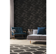 Wohnzimmer mit einem Sofa, einem Sessel und einer Wand mit sechseckigen Paneelen