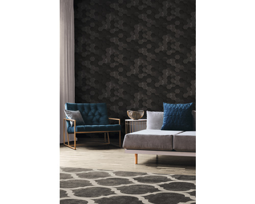 Wohnzimmer mit einem Sofa, einem Sessel und einer Wand mit sechseckigen Paneelen