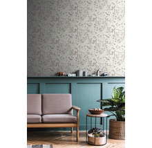 Wohnzimmer mit floral gemusterter Tapete, Sofa, Tisch und Zimmerpflanze