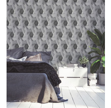 Schlafzimmer mit Bett, Nachttisch und geometrischer Tapete