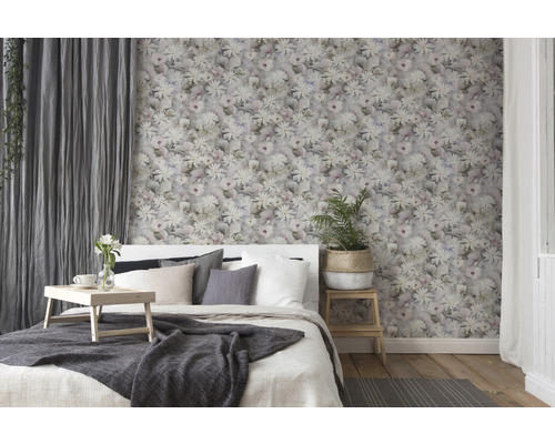 Schlafzimmer mit floraler Tapete, Bett und Vorhängen für eine gemütliche Atmosphäre.