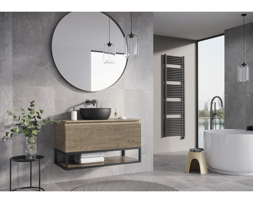Salle de bain moderne avec lavabo, miroir rond, sèche-serviettes et baignoire îlot