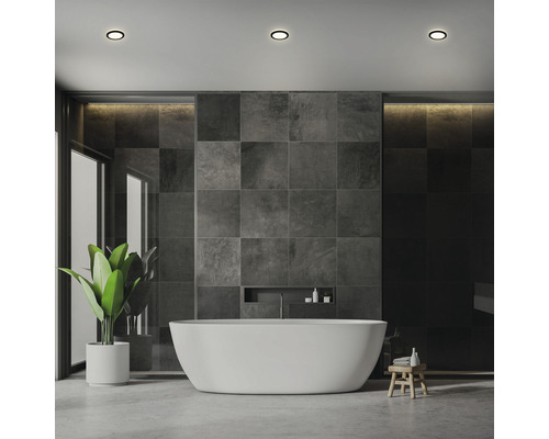 Modernes Badezimmer mit Badewanne, Fliesenwand und Deckenleuchten
