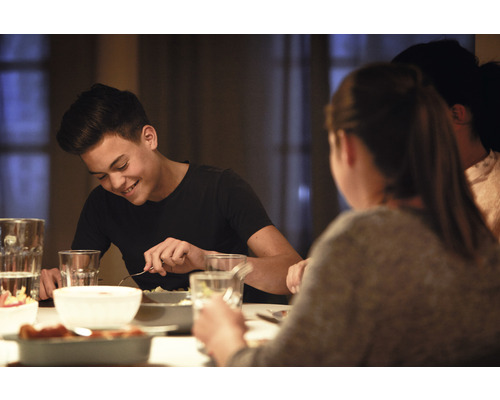 Personnes assises en train de manger à une table avec de la vaisselle