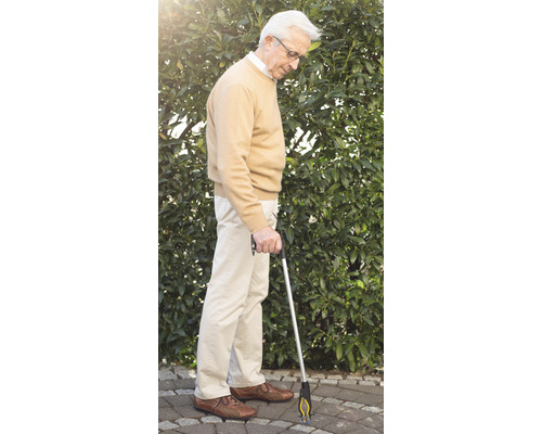 Un homme utilise une aide à la préhension à l''extérieur