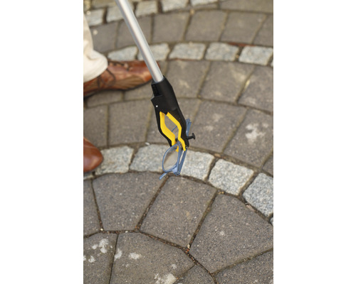 Pince de préhension ramassant une paire de lunettes au sol.