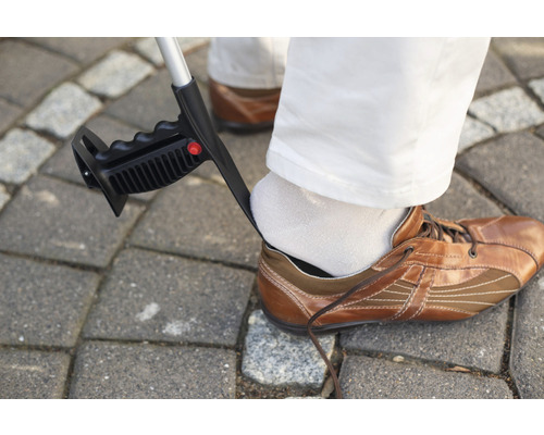 Chausse-pied utilisé pour aider un homme portant des chaussures marron