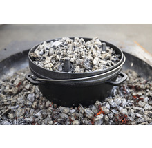Gusseiserner Dutch Oven mit Holzkohle zum Kochen im Freien.