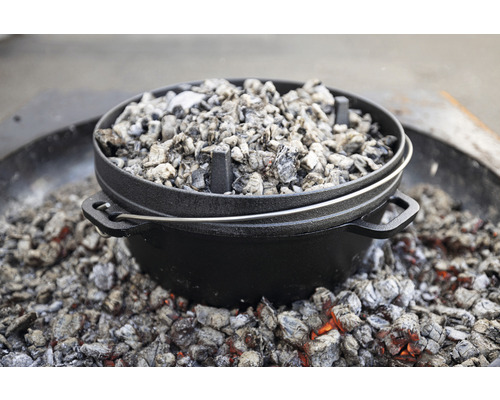 Gusseiserner Dutch Oven mit Holzkohle zum Kochen im Freien.
