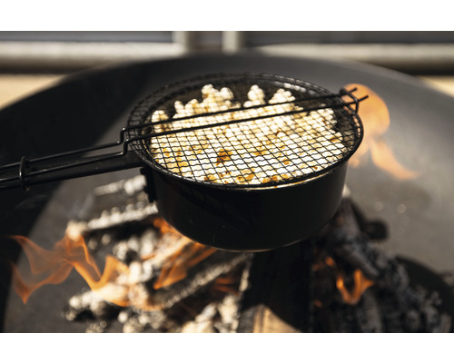 Popcornzubereitung über offenem Feuer in einem Popcorn-Topf