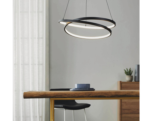 Intérieur moderne avec une suspension LED noire en forme d''anneau au-dessus d''une table en bois