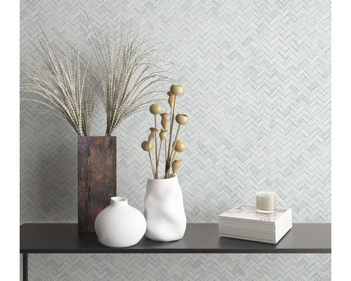 Dekorative Vasen und Pflanzen auf einem Regal vor einer gemusterten Wand