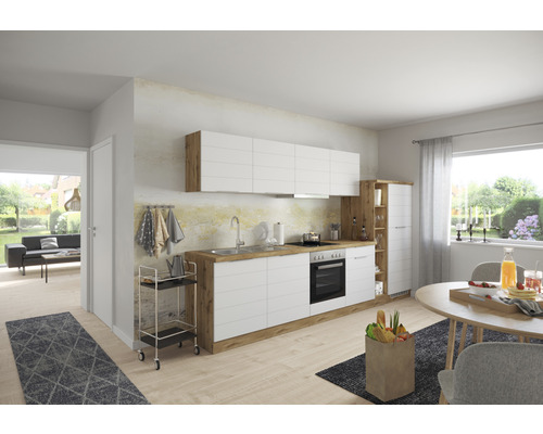 Cuisine claire avec façades blanches et éléments en bois, coin repas avec table et chaises.