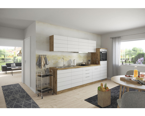 Cuisine moderne avec armoires blanches, détails en bois et table à manger dans une pièce lumineuse.