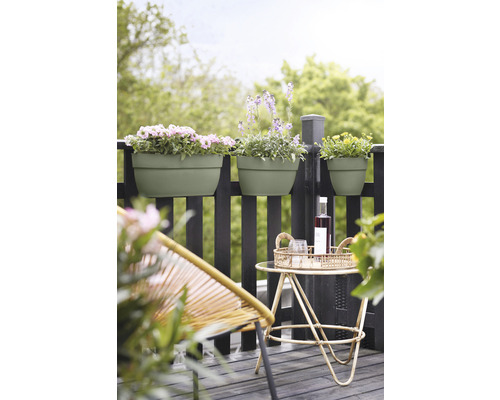 Scène de balcon avec jardinières plantées, table d''appoint et fauteuil en rotin