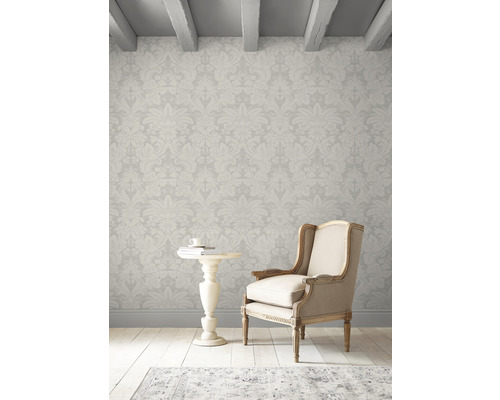 Innenraum mit floral gemusterter Tapete, Sessel und Beistelltisch