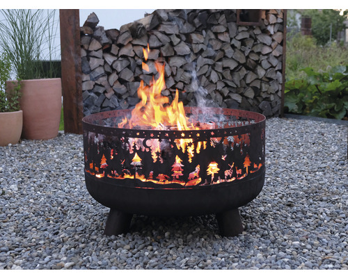 Feuerstelle aus Metall mit Ausschnitten von Bäumen und Tieren im Garten