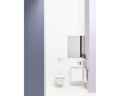 Salle de bain lumineuse avec WC suspendu, lavabo, miroir et porte-serviettes