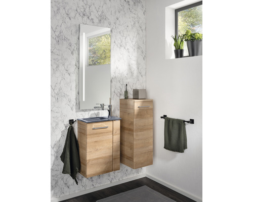 Badezimmer mit Waschtisch, Spiegelschrank und Hochschrank in Holzoptik vor einer Marmorwand