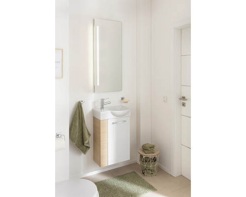 Salle de bain lumineuse avec lavabo, miroir et décoration