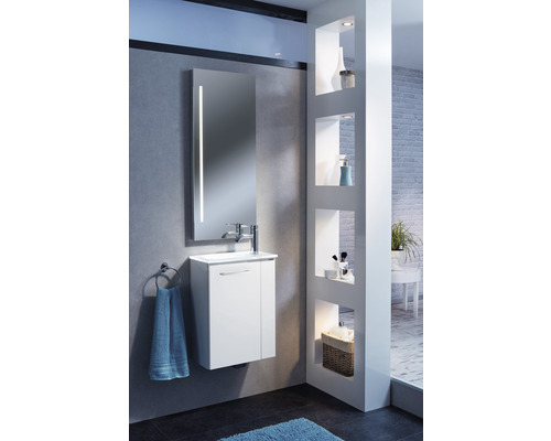 Modernes Badezimmer mit weißem Waschtisch, Spiegel mit Beleuchtung und Regal